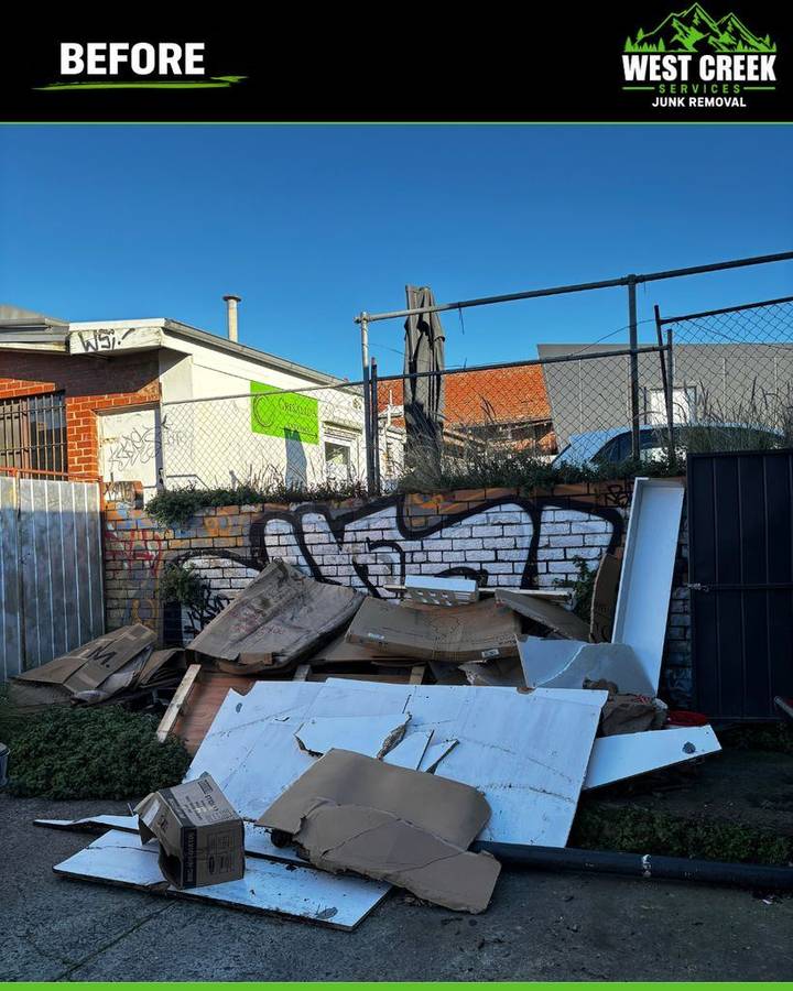 Before: Cardboard and panelling dumped against a commercial wall